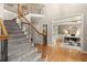 Bright foyer featuring hardwood floors, staircase with iron spindles, and access to a home office at 4300 May Apple Dr, Alpharetta, GA 30005