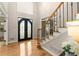 Bright foyer with hardwood floors, staircase with iron spindles, and elegant double front doors at 4300 May Apple Dr, Alpharetta, GA 30005