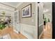 Hallway with beautiful hardwood floors, neutral paint, and access to living spaces and staircase at 4300 May Apple Dr, Alpharetta, GA 30005