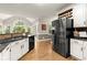 Bright kitchen featuring white cabinets, stainless steel appliances, dark countertops, and eat-in breakfast area at 4300 May Apple Dr, Alpharetta, GA 30005
