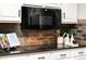 Elegant kitchen featuring modern microwave, granite countertops, decorative backsplash, and white cabinets at 4300 May Apple Dr, Alpharetta, GA 30005