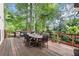 Spacious deck surrounded by lush trees, outdoor dining furniture, and space for grilling and entertaining at 4300 May Apple Dr, Alpharetta, GA 30005