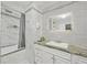 Modern bathroom featuring tiled walls and tub, neutral paint, decorative mirror, and built-in vanity at 5242 Mccarter Sta, Stone Mountain, GA 30088