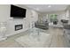 Bright living room with hardwood floors, neutral paint, fireplace, large windows, and open layout to dining area at 5242 Mccarter Sta, Stone Mountain, GA 30088