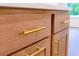 Close up of wood kitchen cabinetry with long, gold, bar-style handles at 6525 Rhett Run, Cumming, GA 30028