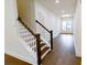 Bright entryway features wood stairs with white risers, a light fixture, and wood flooring at 6525 Rhett Run, Cumming, GA 30028