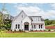 Charming gray two-story home with white brick accents and a well-manicured lawn and landscape at 6525 Rhett Run, Cumming, GA 30028