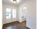Bright foyer featuring hardwood floors, double glass doors, and white trim throughout at 6525 Rhett Run, Cumming, GA 30028