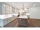 Bright kitchen featuring stainless steel appliances, hardwood floors, a large island, and pendant lights at 6525 Rhett Run, Cumming, GA 30028
