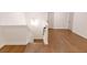 Upstairs landing with wood floors, a staircase, and multiple doors on the right at 6525 Rhett Run, Cumming, GA 30028