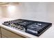 Close-up of the stovetop with stainless steel knobs on countertop with white tiled backsplash at 6525 Rhett Run, Cumming, GA 30028