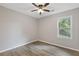 A sunny bedroom offers neutral paint, ceiling fan and light and bright flooring with an exterior window at 1841 Surrey Hill Cir, Lawrenceville, GA 30044