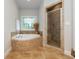 Bathroom featuring a soaking tub with tile surround and a glass-enclosed shower at 1865 Mason Mill Rd, Decatur, GA 30033