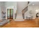 Bright foyer with hardwood floors, wooden staircase, and view into the living area through french doors at 1865 Mason Mill Rd, Decatur, GA 30033