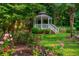 Landscaped yard featuring a charming gazebo surrounded by lush greenery and vibrant roses at 1865 Mason Mill Rd, Decatur, GA 30033