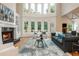 Sunlit living room with soaring ceilings, a fireplace, and large windows, creating a bright and inviting space at 1865 Mason Mill Rd, Decatur, GA 30033