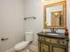 Charming powder room featuring a decorative vanity and a framed mirror above the black countertop sink at 1865 Mason Mill Rd, Decatur, GA 30033
