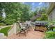 Outdoor deck with grill, seating, and peaceful, private views of the surrounding trees at 4275 Green Summers Dr, Cumming, GA 30028