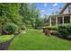 Lush backyard with mature trees, landscaped garden beds, and outdoor living space at 4275 Green Summers Dr, Cumming, GA 30028