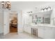 A bright bathroom features double sinks, large mirrors, modern lighting, and an open doorway to the bedroom at 4275 Green Summers Dr, Cumming, GA 30028
