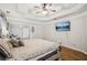A spacious main bedroom featuring a tray ceiling, ceiling fan, hardwood floors, and a television at 4275 Green Summers Dr, Cumming, GA 30028