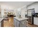 Bright kitchen with a gray center island, stainless steel refrigerator and view of the breakfast and living areas at 4275 Green Summers Dr, Cumming, GA 30028