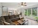 Open-concept living room with large windows, hardwood floors, and a comfortable sectional sofa at 4275 Green Summers Dr, Cumming, GA 30028