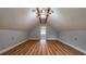 Bright attic space featuring wood-look floors, neutral walls, a ceiling fan, and a connecting room at 6109 N Main Se St, Acworth, GA 30101
