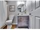 Cozy bathroom features a vanity with drawers, a circular mirror, toilet, shower with curtain and neutral walls at 845 Connell Ln, Lawrenceville, GA 30044