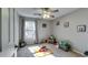 Neutral bedroom shows a ceiling fan, gray walls, plush carpet, a window, and play items, making it kid-friendly at 845 Connell Ln, Lawrenceville, GA 30044