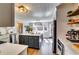 Kitchen featuring stainless steel appliances, island with dark gray cabinets, and wooden floating shelves at 845 Connell Ln, Lawrenceville, GA 30044