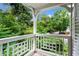A quaint balcony features white lattice railing and views of lush greenery and distant blue skies at 111 Abingdon Way, Sandy Springs, GA 30328