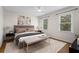 Bright bedroom featuring two windows, a ceiling fan, neutral walls and carpet, and a comfortable bed with accent pillows at 111 Abingdon Way, Sandy Springs, GA 30328