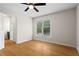 Bedroom features wood floors, neutral walls, a ceiling fan, and an open doorway into a bathroom at 111 Abingdon Way, Sandy Springs, GA 30328