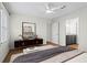 View of bedroom reveals a dark dresser, large mirror, ceiling fan, open door to ensuite bathroom with granite vanity at 111 Abingdon Way, Sandy Springs, GA 30328