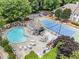 Aerial view of a refreshing pool, tennis court, and gazebo surrounded by lush trees and greenery at 111 Abingdon Way, Sandy Springs, GA 30328