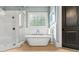Bathroom featuring a glass enclosed shower, soaking tub, tile floors, and decorative window at 5114 Brendlynn Dr, Suwanee, GA 30024