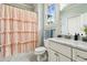 Bathroom featuring a shower with ruffled pink curtain, single vanity, and marble countertops at 5114 Brendlynn Dr, Suwanee, GA 30024