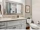 Powder room featuring a granite countertop, white cabinets, and a decorative mirror at 5114 Brendlynn Dr, Suwanee, GA 30024