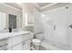 Beautiful bathroom with white tile, glass enclosed shower and marble countertop at 5114 Brendlynn Dr, Suwanee, GA 30024