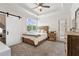 Bedroom featuring a sliding barn door, a ceiling fan and a neutral color scheme at 5114 Brendlynn Dr, Suwanee, GA 30024