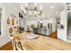 Open-concept dining area with lots of light, a rustic table and views of the modern open kitchen at 5114 Brendlynn Dr, Suwanee, GA 30024