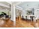 Open concept living area with wood floors connecting dining, living, and entertainment spaces at 5114 Brendlynn Dr, Suwanee, GA 30024