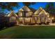 Charming stone and brick home with well-lit landscape and manicured lawn creates a welcoming curb appeal at 5114 Brendlynn Dr, Suwanee, GA 30024