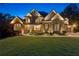 Beautiful two-story brick home with manicured lawn, professional landscaping, and elegant lighting at 5114 Brendlynn Dr, Suwanee, GA 30024