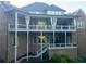View of the home's brick rear elevation, with a multi-level deck and covered patio at 5114 Brendlynn Dr, Suwanee, GA 30024