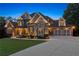 Elegant brick and stone home with lush landscaping, featuring a spacious two-car garage and well-maintained lawn at 5114 Brendlynn Dr, Suwanee, GA 30024