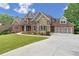Beautiful home featuring brick and stone accents, a three-car garage, and a well-maintained front yard at 5114 Brendlynn Dr, Suwanee, GA 30024