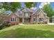 Picturesque two-story home featuring brick and stone elements, complemented by a well-kept front yard at 5114 Brendlynn Dr, Suwanee, GA 30024