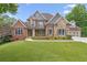 Attractive two-story home with a combination of brick and stone, surrounded by a lush, green lawn at 5114 Brendlynn Dr, Suwanee, GA 30024